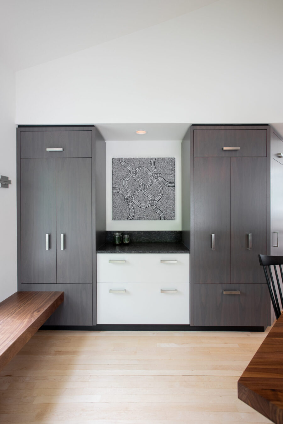 Contemporary custom renovation: extensive gray cabinetry, elegant white built-ins.