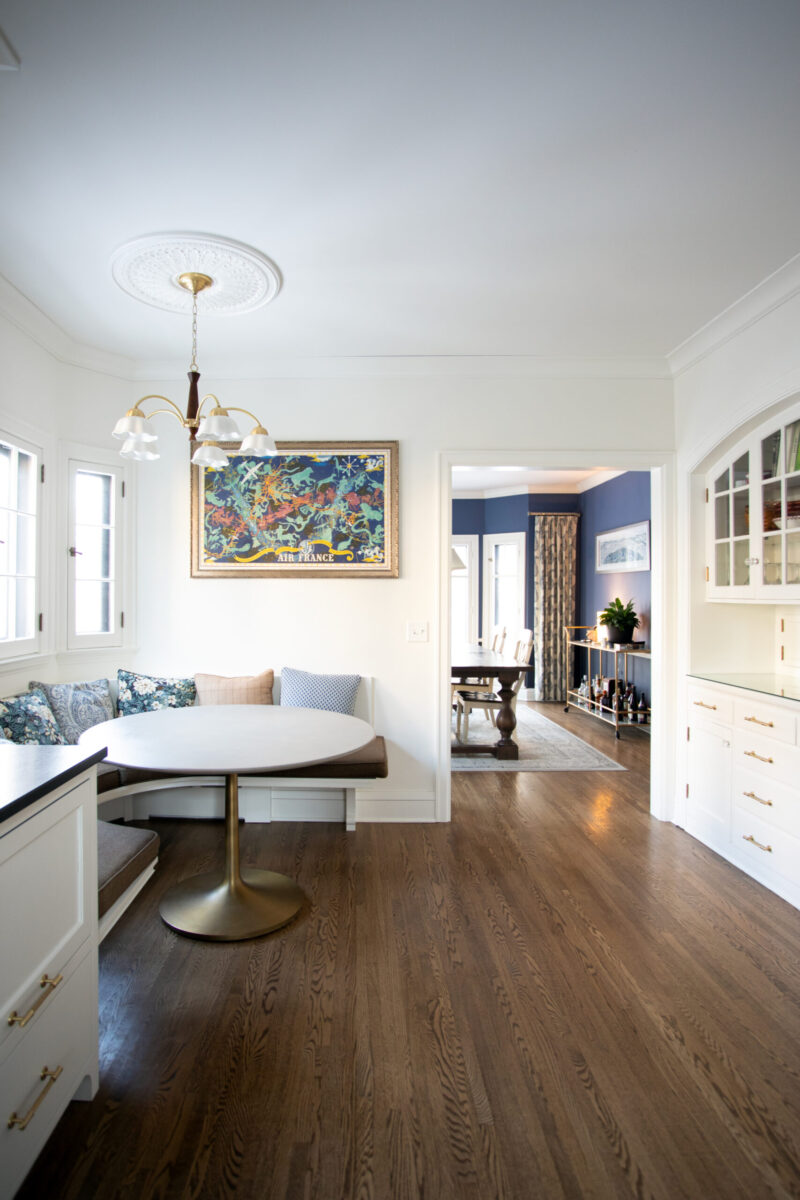 Twin Cities kitchen remodel: bright nook boasts white built-in cabinetry, custom banquette, and dark hardwood floors.