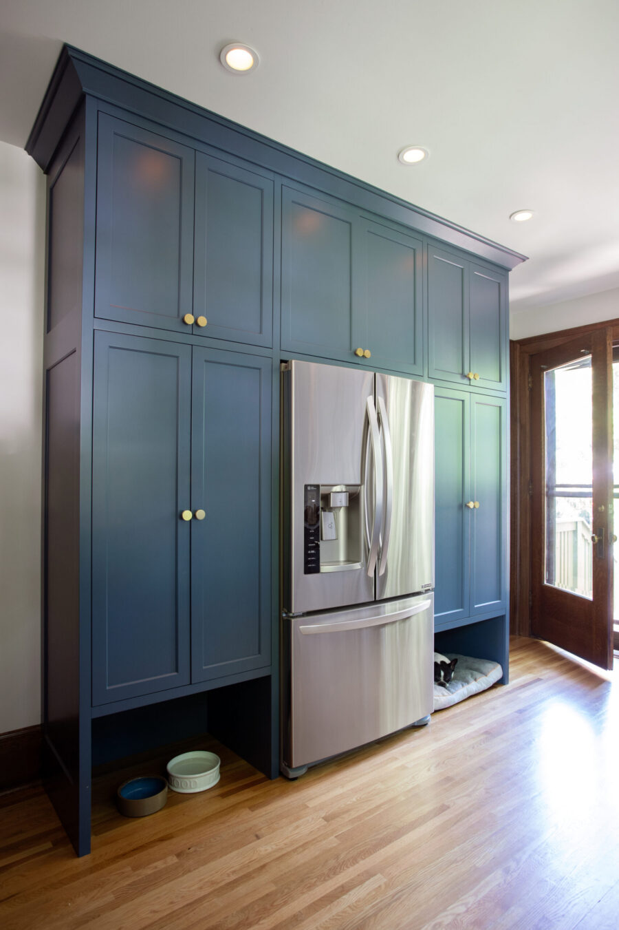 Custom blue kitchen cabinetry, steel refrigerator, hardwood floors. Remodel.