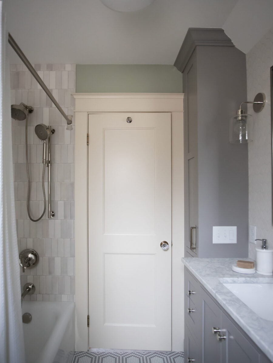 Remodeled Twin Cities bathroom features gray vanity, marble, white subway tile shower.