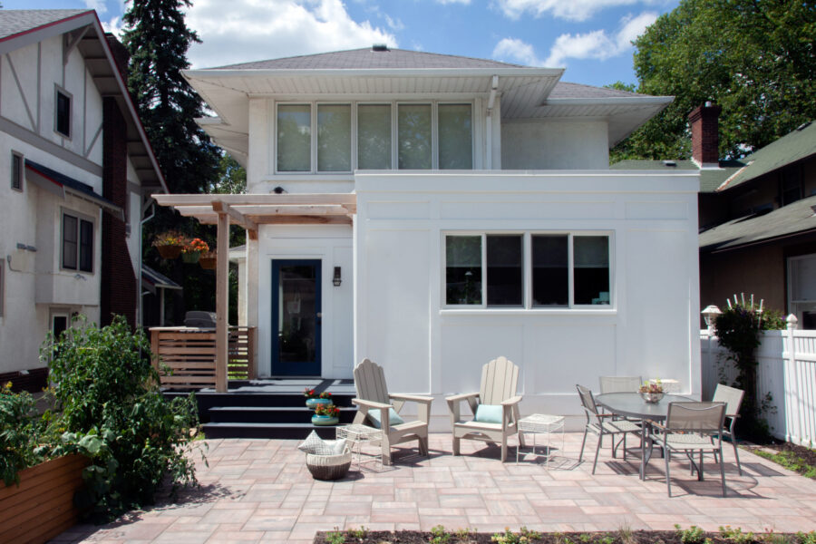 Architectural contemporary exterior renovation incorporates expansive paver patio, pergola.