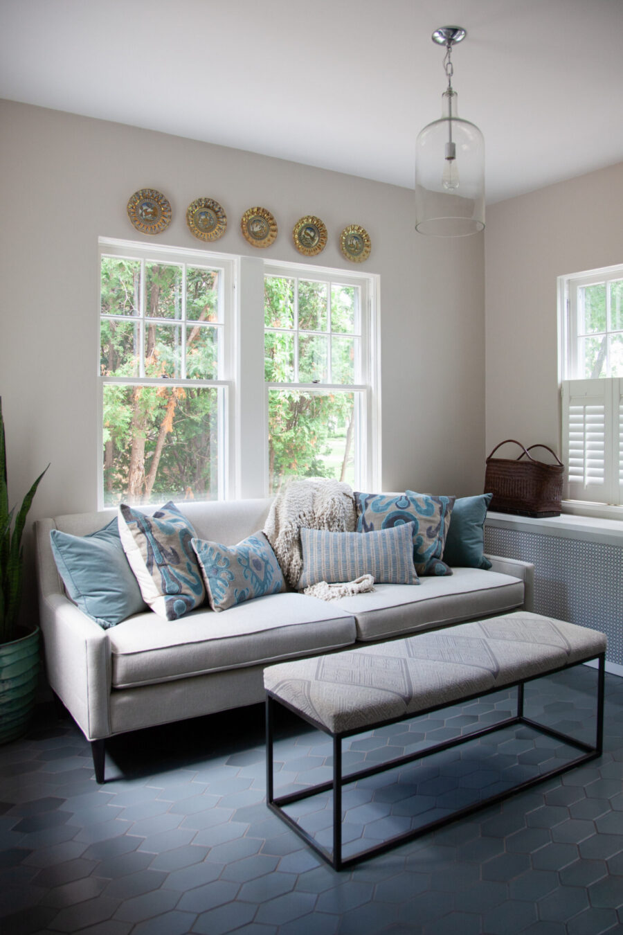 Twin Cities residential renovation presents comfortable grey sofa, hexagonal flooring.