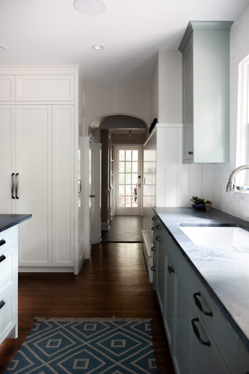 Twin Cities kitchen renovation features light-toned cabinetry, dark countertops, and wood floors.
