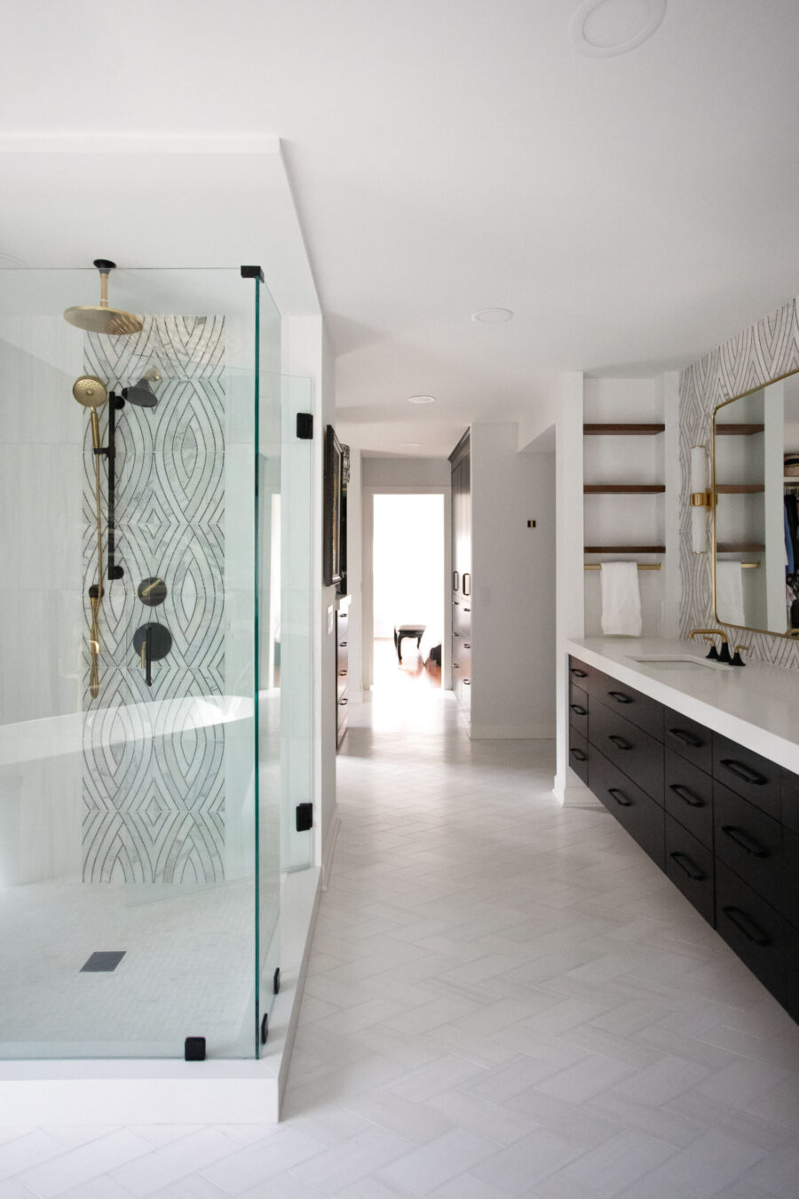 Twin Cities luxurious renovation features expansive glass shower, patterned tile.