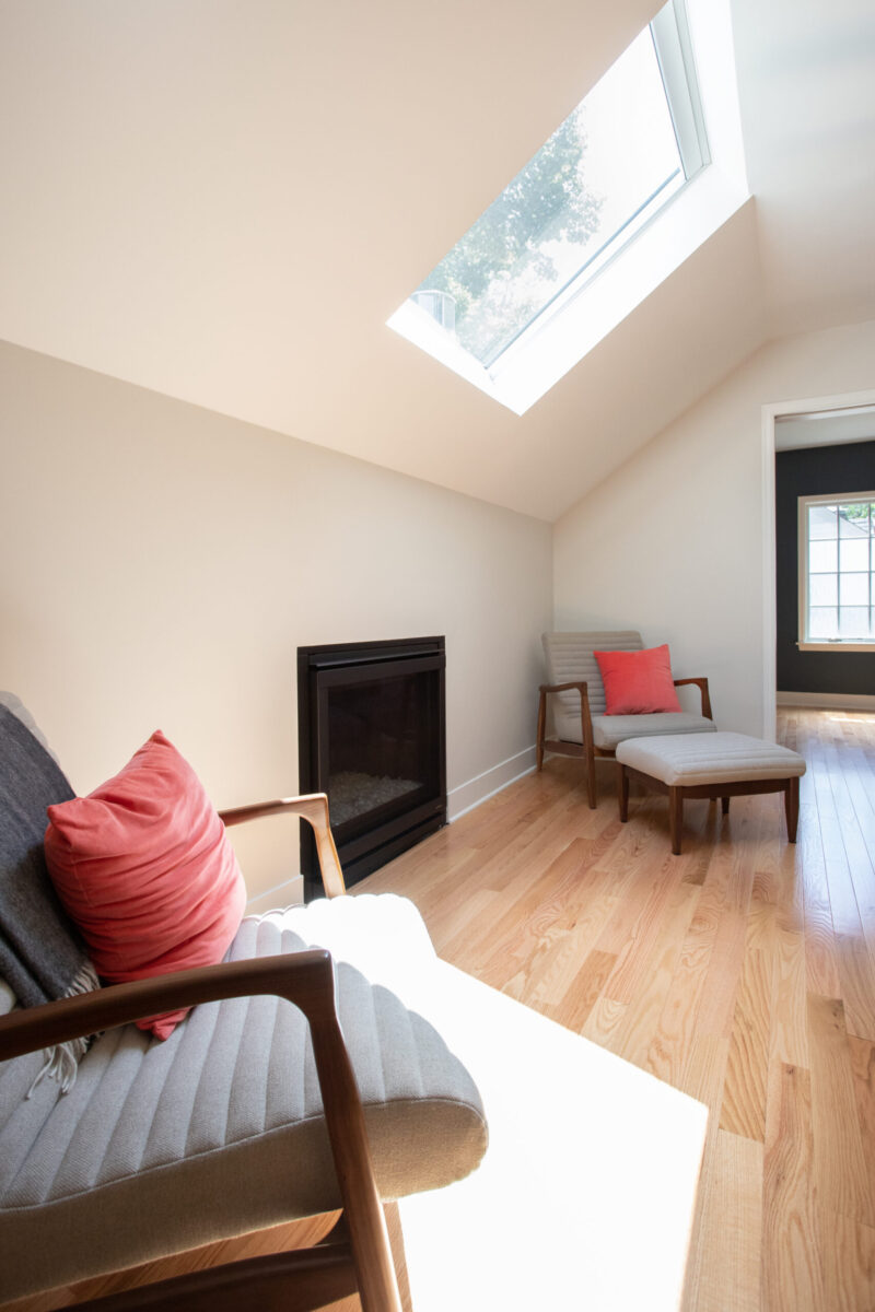 Bright Twin Cities remodel includes skylight, fireplace, light wood floors, and seating.