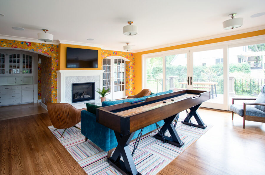Twin Cities design-build integrates bright living, shuffleboard, fireplace, built-ins, and deck.