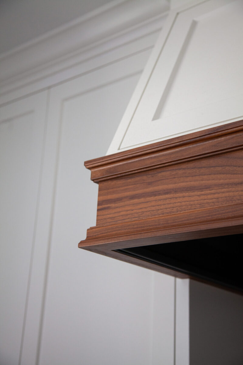 Custom wood range hood molding enriches elegant Twin Cities kitchen remodel.