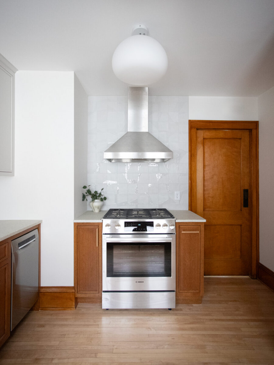 Twin Cities kitchen renovation utilizes stainless appliances, warm wood cabinetry, and white tile backsplash.