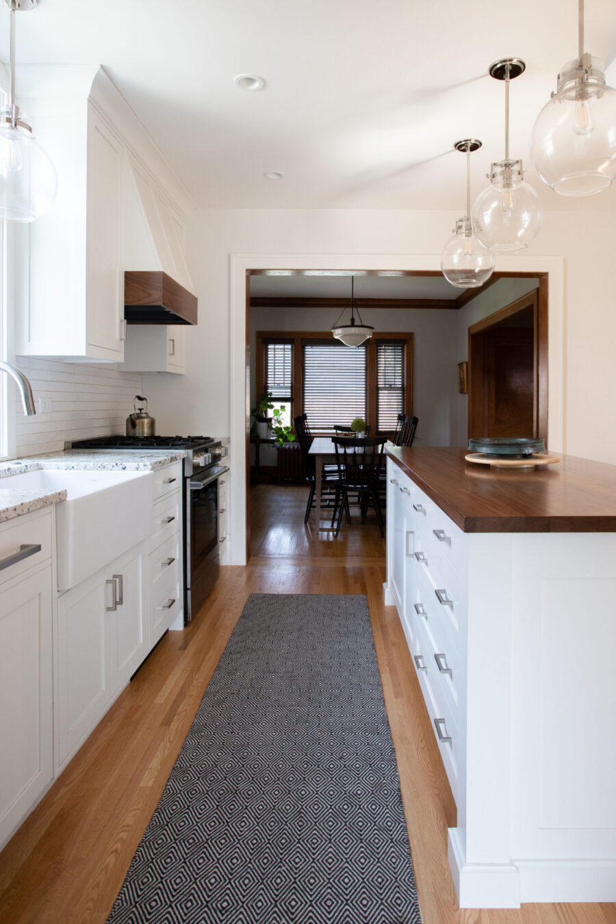 Modern Twin Cities kitchen remodel blends white cabinetry, dark wood, and pendant lighting.