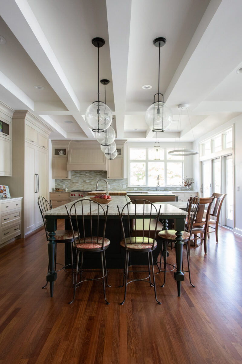 Twin Cities kitchen remodel features large island, coffered ceiling, globe pendant lights.