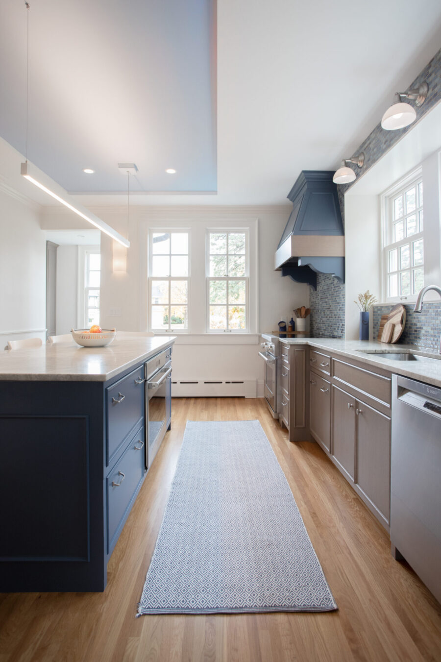 Twin Cities kitchen-remodel boasts a navy-island, gray-cabinets, marble-counters, wood-flooring.