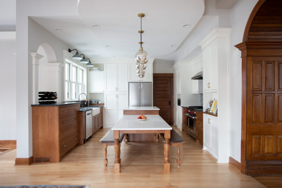 Twin Cities kitchen remodel features white cabinetry, wood elements, large island, task lighting.