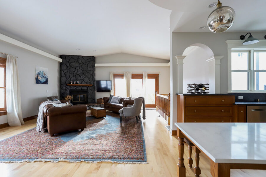 Living room renovation: stone fireplace, hardwood, bright natural light.