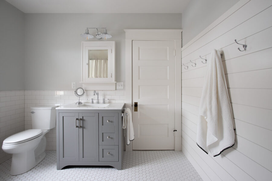 Twin Cities bathroom remodel features white subway tile, gray vanity, shiplap wall, and hexagonal floor tile.