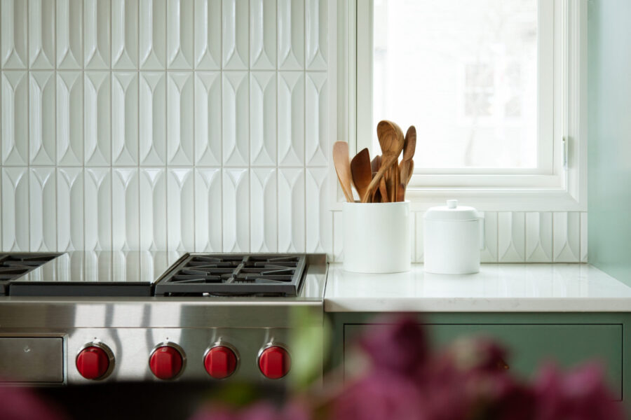 Modern kitchen remodel features white textured backsplash, stainless steel cooktop.