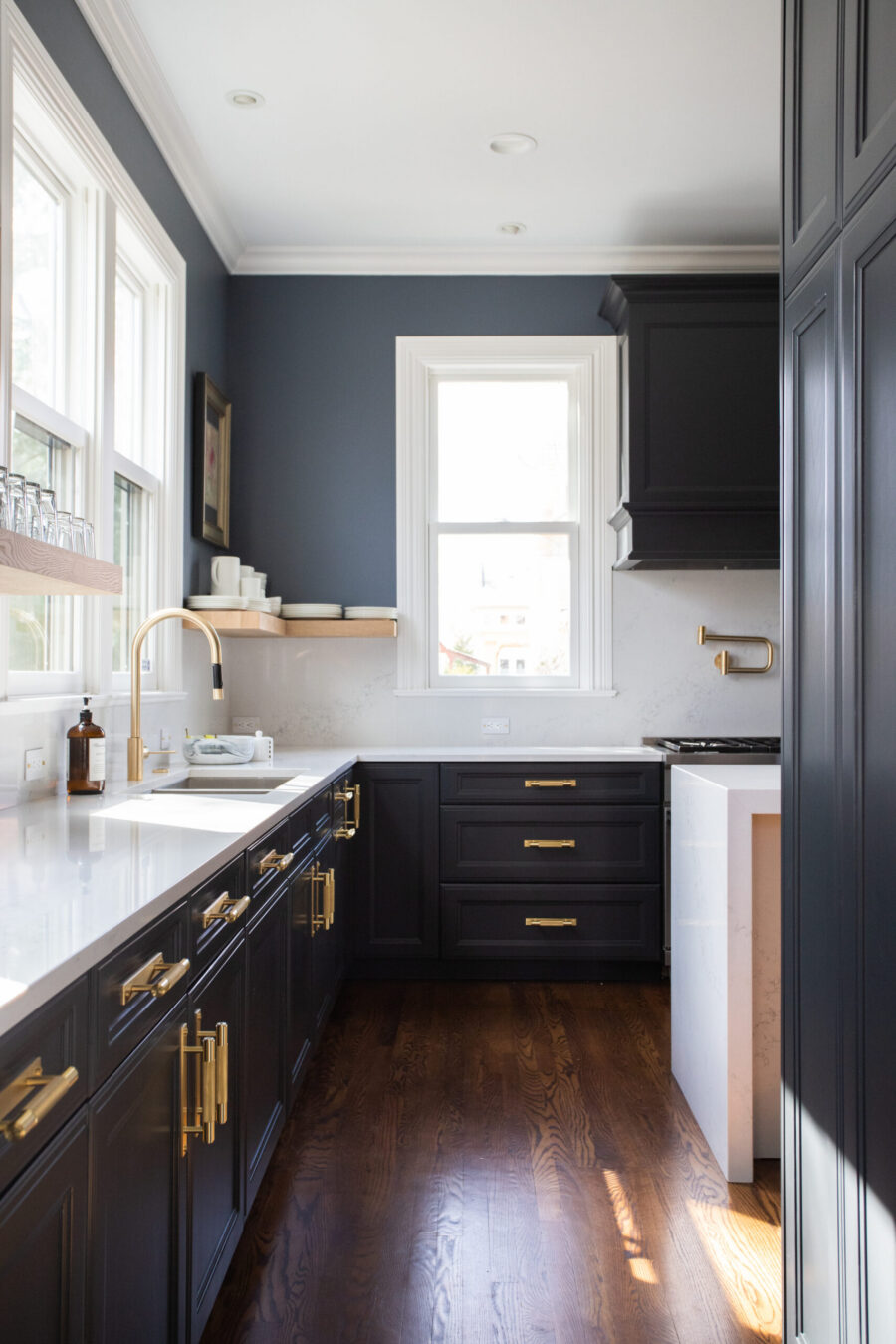 Twin Cities kitchen remodel: dark cabinets, gold hardware, white quartz counters.