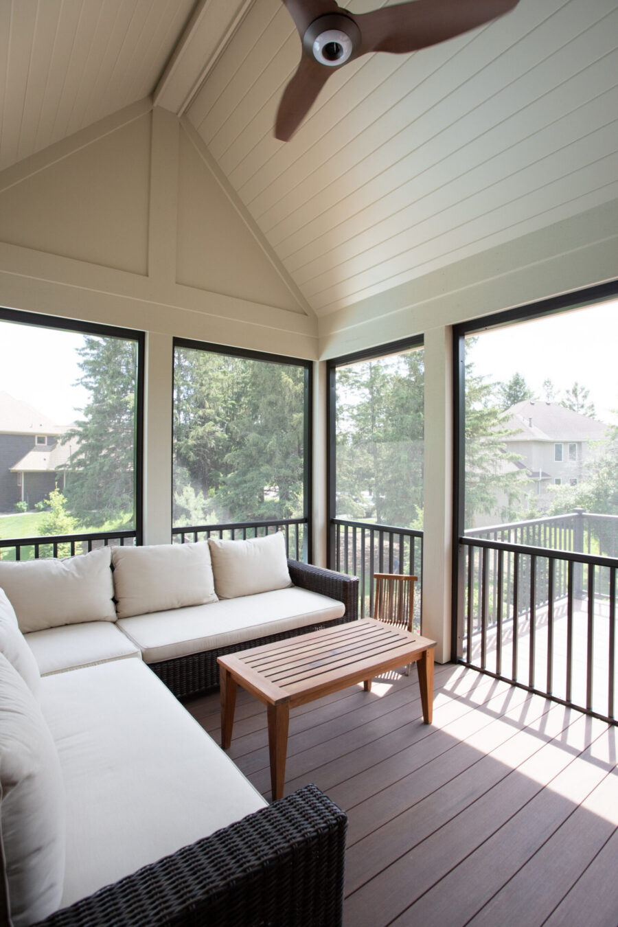 Vaulted screened-porch renovation features outdoor-furniture, composite-decking, ceiling-fan.