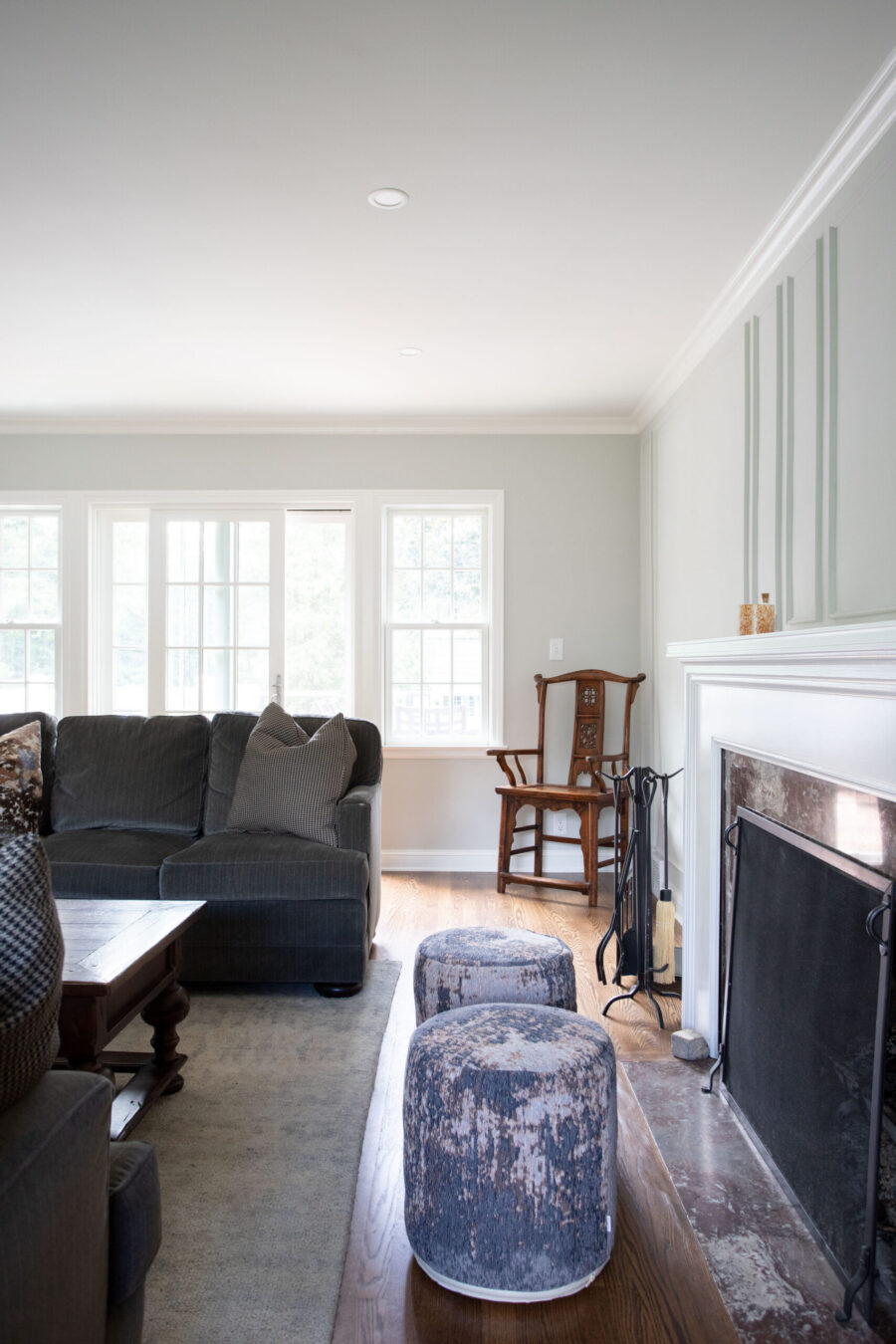 Twin Cities home remodel: white fireplace, gray sofa, large windows, hardwood, recessed lighting.
