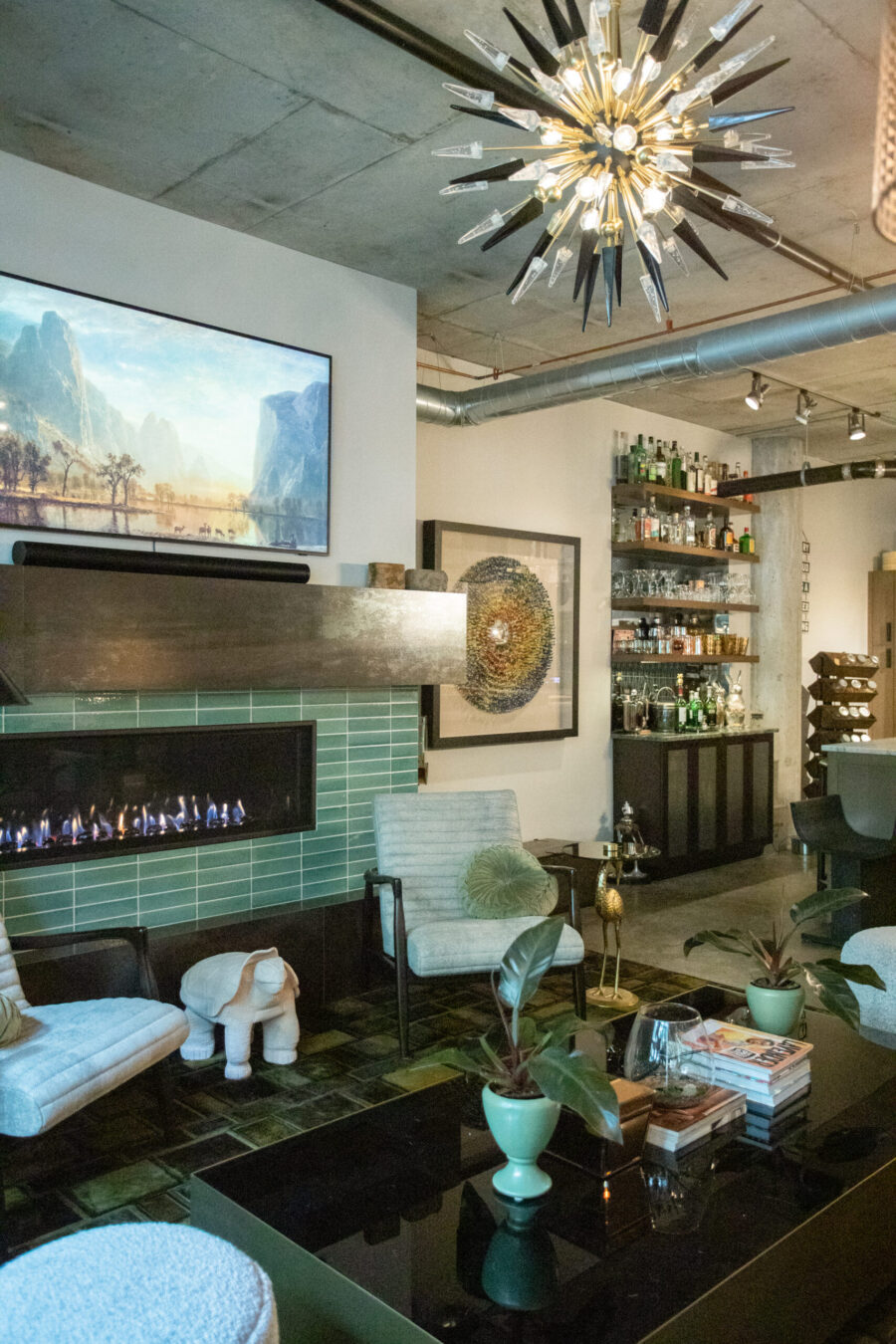 Renovation features green tiled fireplace, built-in bar, concrete ceiling.