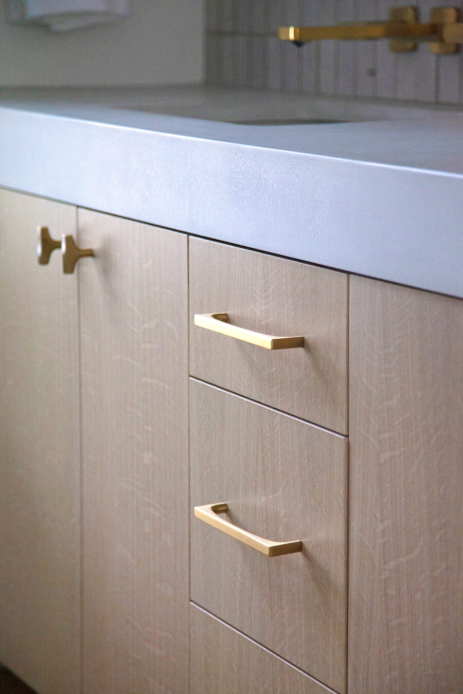 Twin Cities bathroom remodel design-build features concrete countertop, brass hardware.