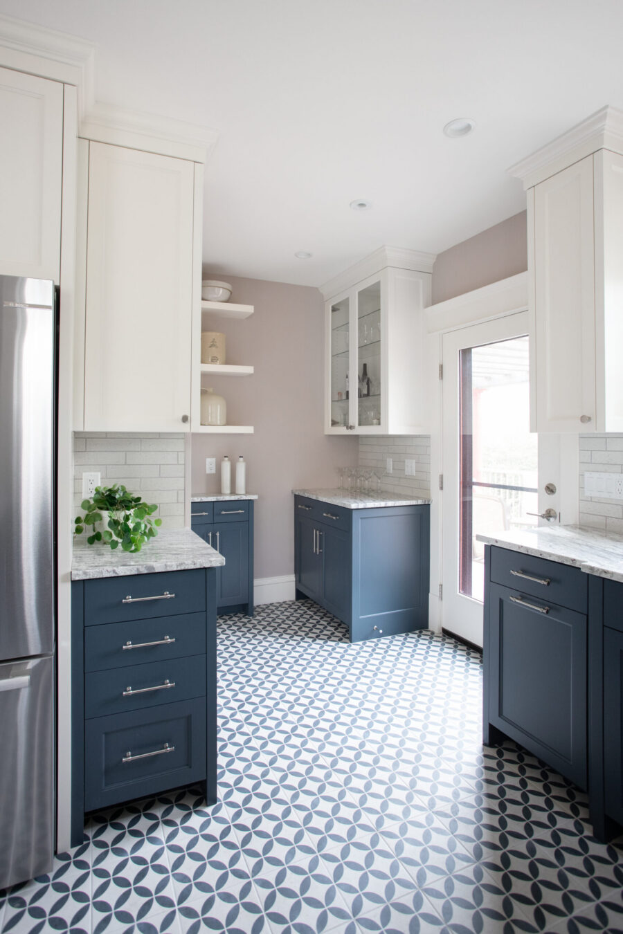 Twin Cities kitchen remodel: white upper, navy lower cabinets. Geometric floor tiles, subway backsplash, stone counters. Recessed lighting.