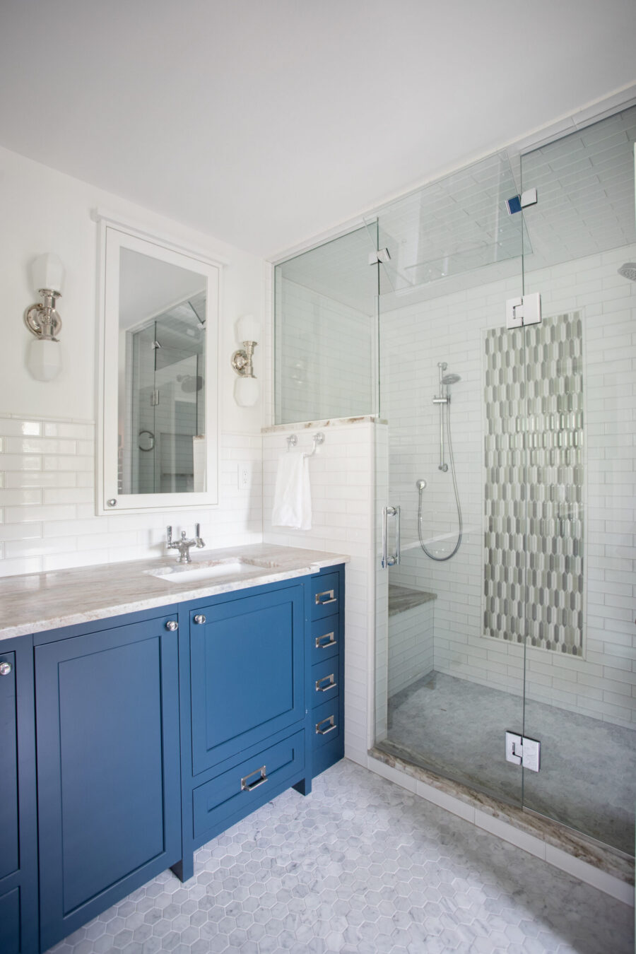 Twin Cities bathroom remodel. Blue vanity, marble counter, glass shower, white subway, hexagon tiles.
