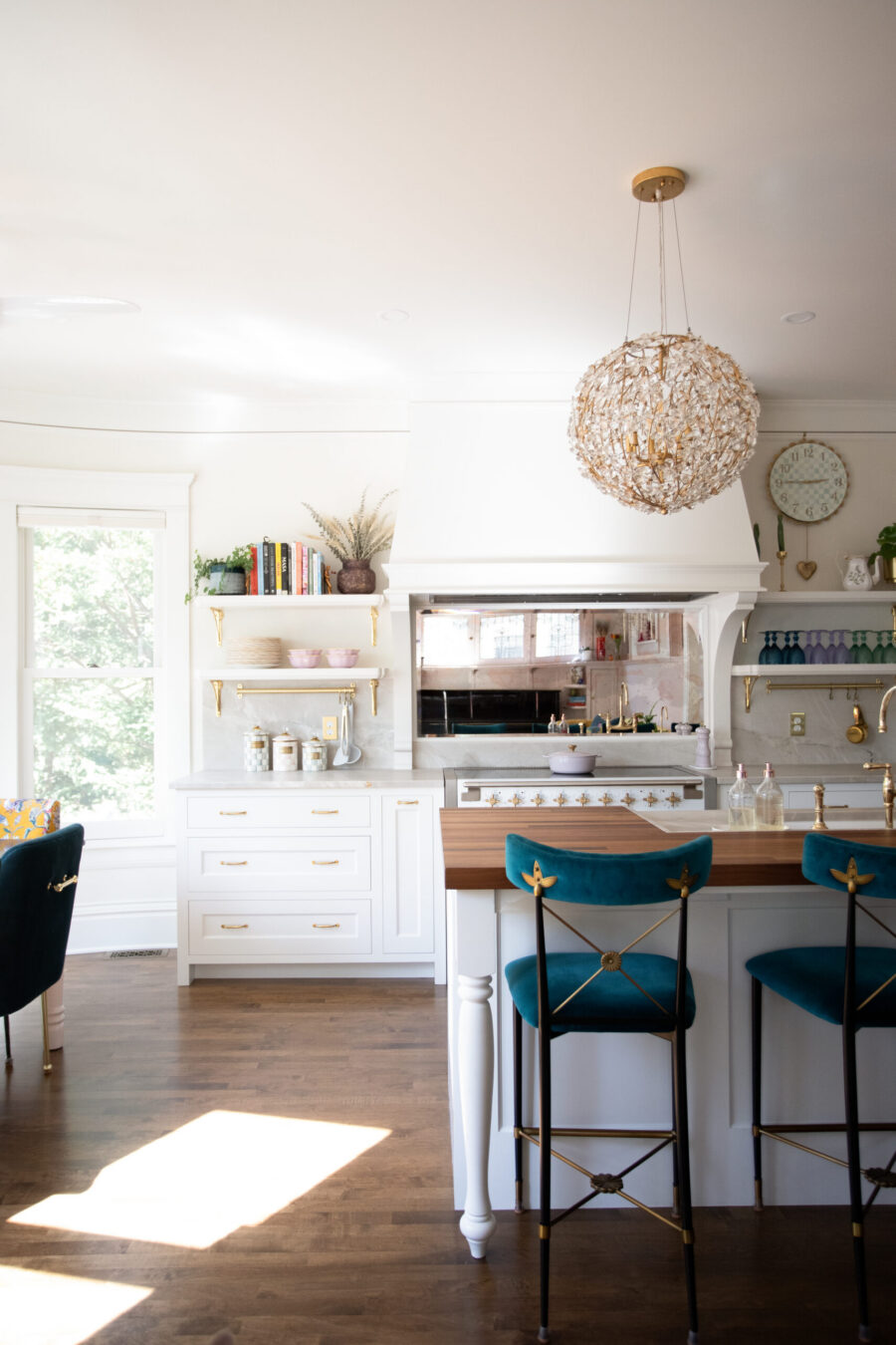 Bright Twin Cities kitchen remodel features white cabinets, wood island, and a sparkling chandelier.