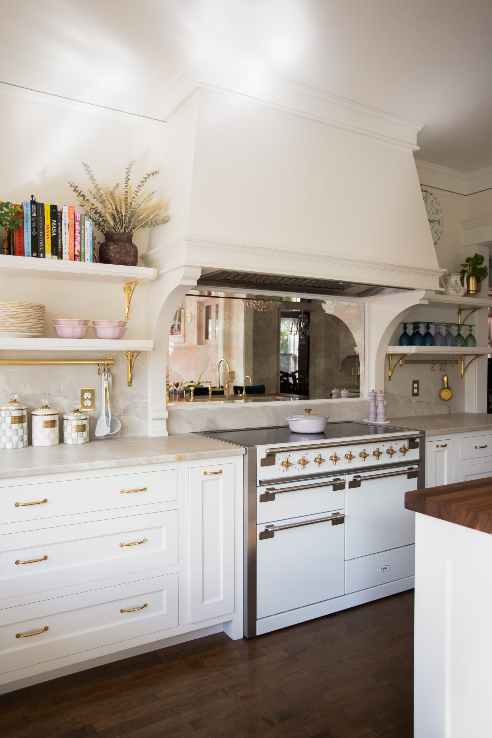 Bright-white custom kitchen features honed-marble countertops, hand-painted tile backsplash.