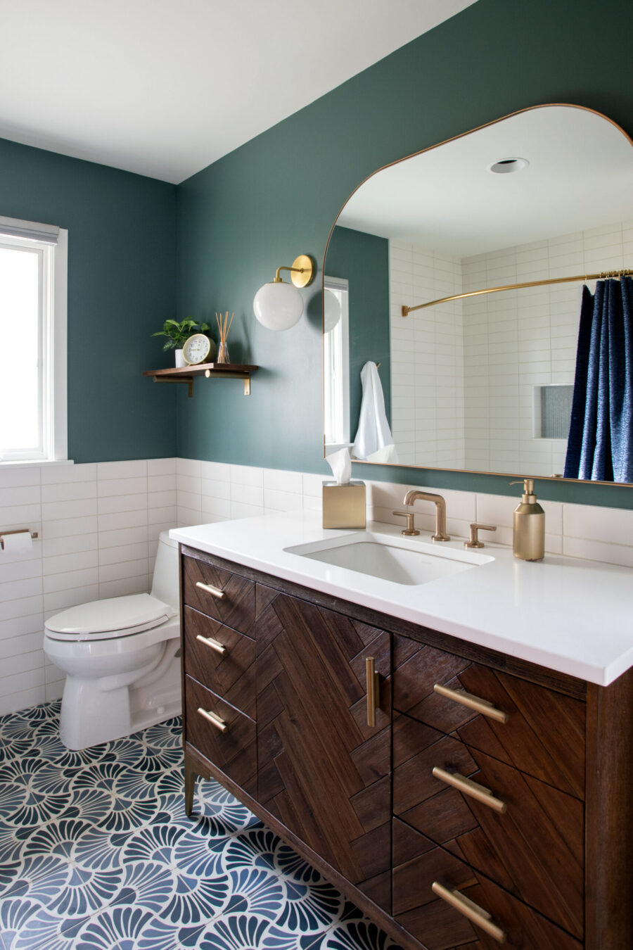 Twin Cities dark-teal-walled bathroom renovation, patterned floor, herringbone vanity.