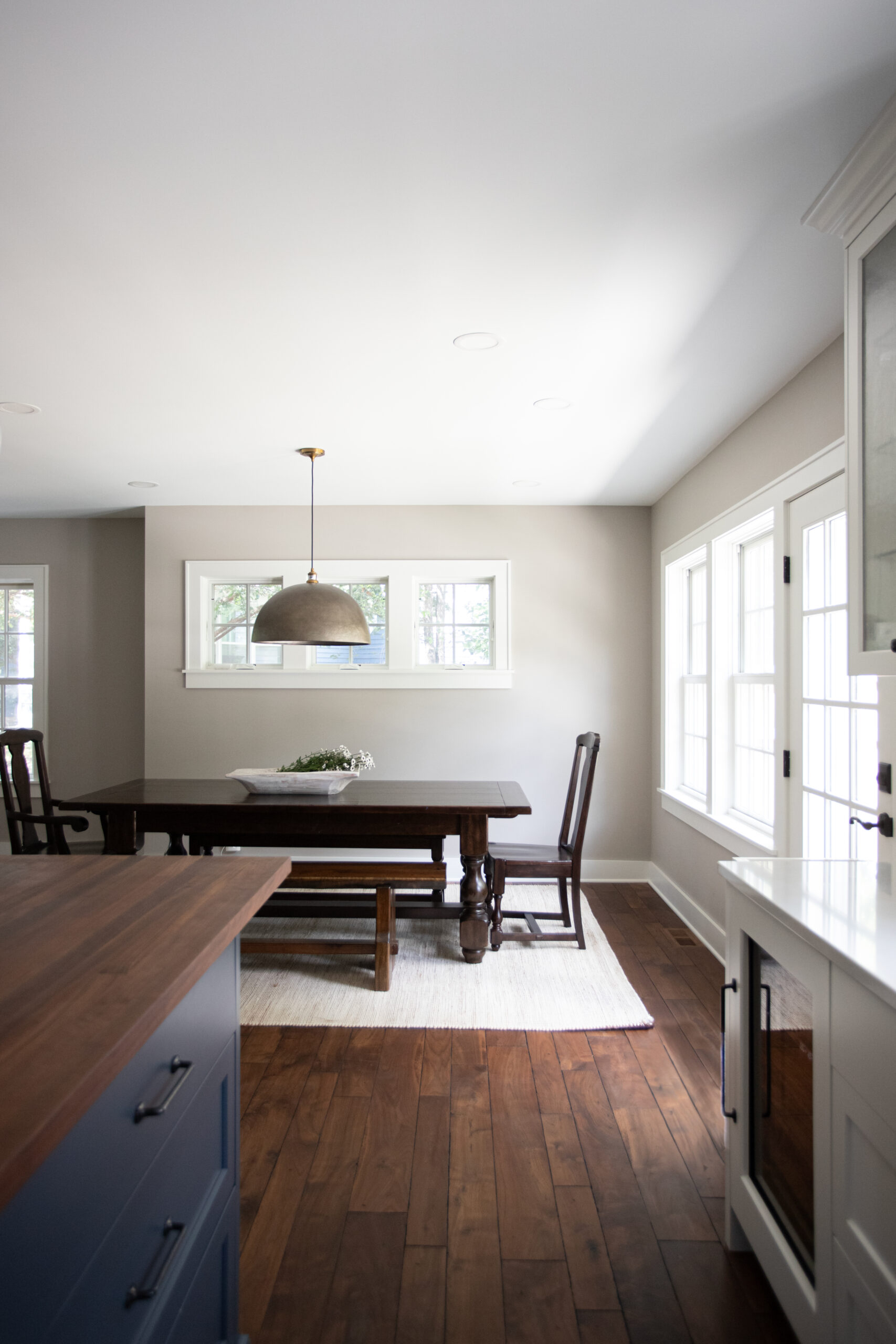 Twin Cities dining-space has deep-dark-stained wide-plank hardwood flooring, pendant-light