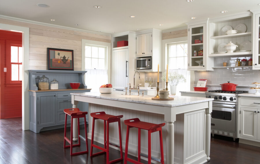 Bright Twin Cities kitchen remodel features white cabinetry, marble island, red accents.