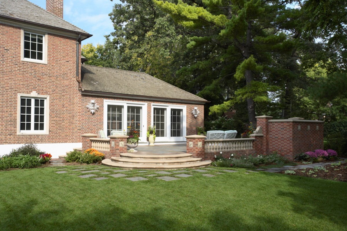 Brick-clad facade features expansive flagstone-terrace, balustrade, semicircular steps