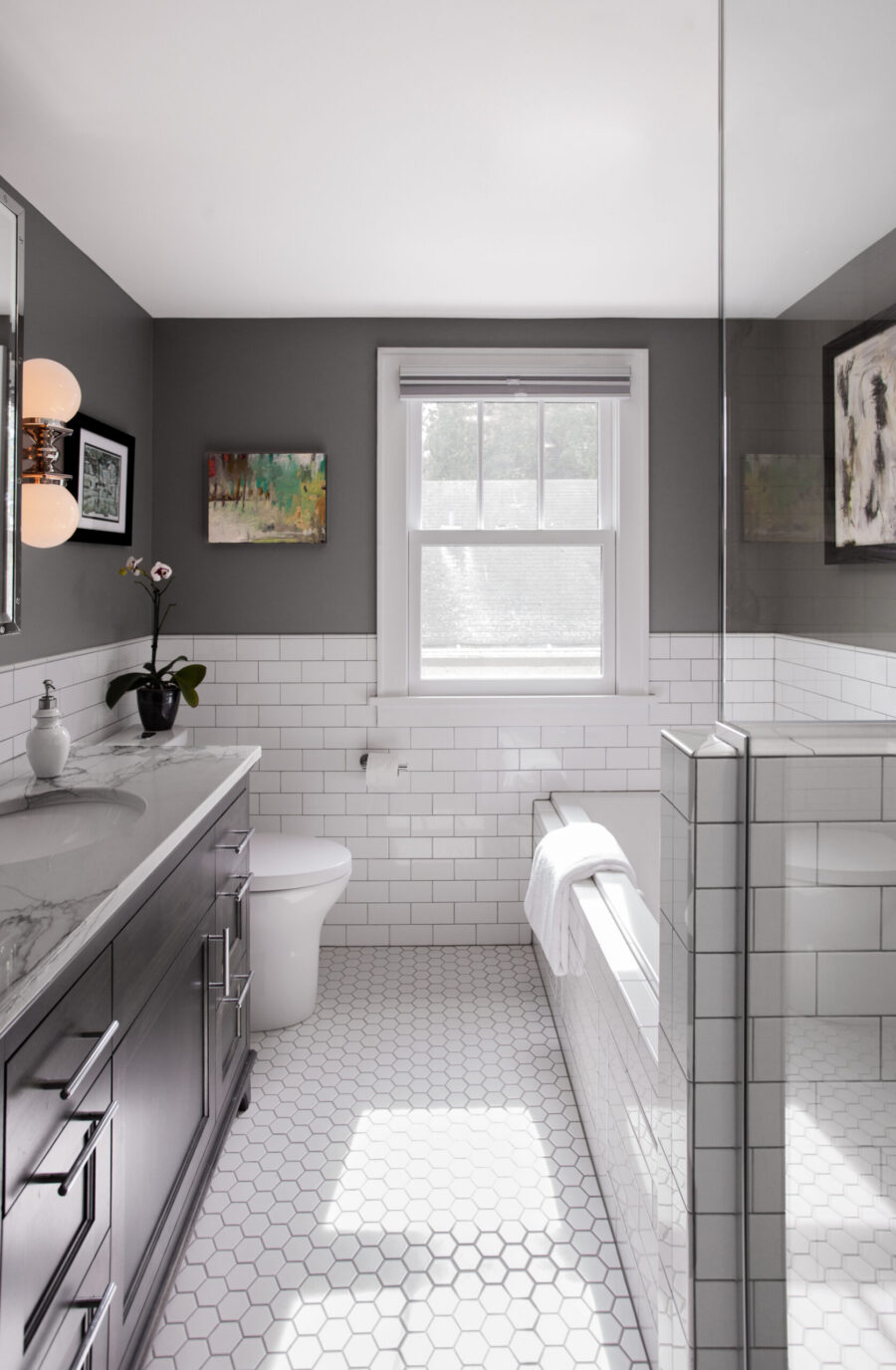 Modern Twin Cities bathroom renovation: dark gray walls, white subway and hexagon tiles, dark vanity, bright natural light.