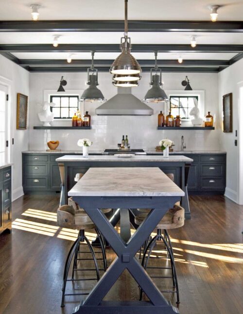 Twin Cities kitchen remodel: dark cabinetry, marble surfaces, industrial pendants, wood flooring.