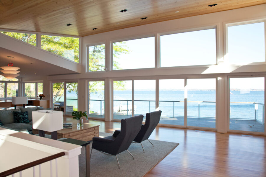 Bright Twin Cities interior design offers panoramic lake views, light wood ceiling.