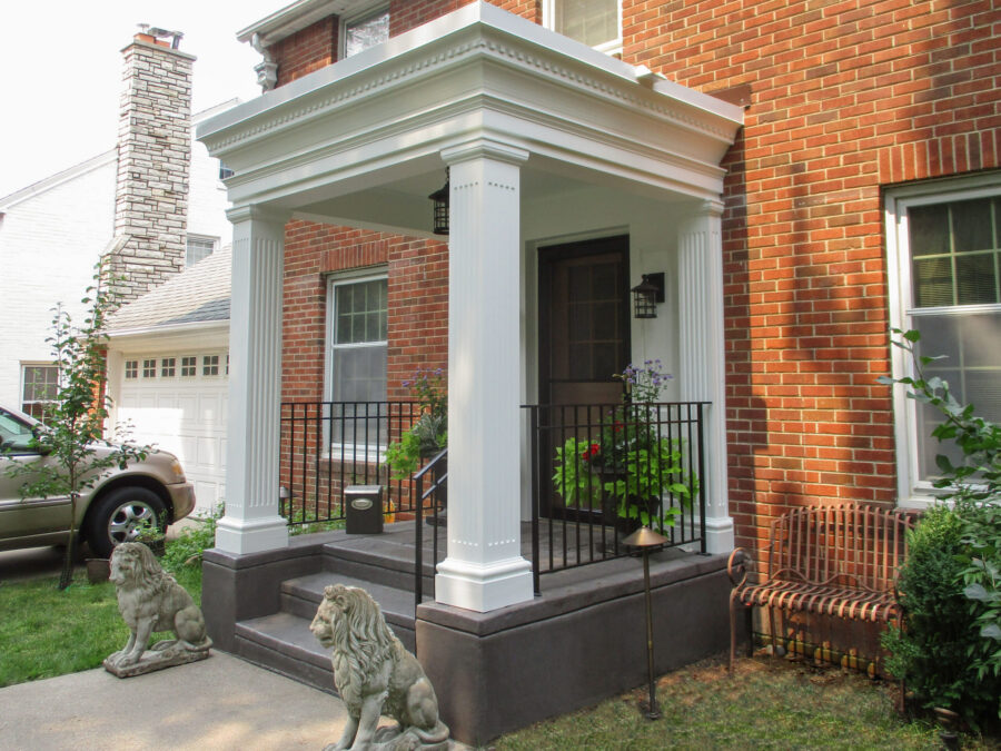 Architectural home renovation: stately brick dwelling gains elegant white columned entryway.