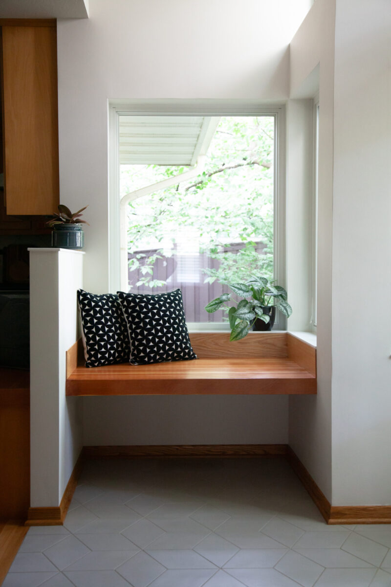 Bright Twin Cities renovation combines wood bench, geometric floor, clean white walls.