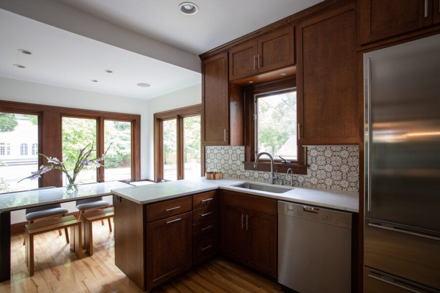 Twin Cities home renovation: rich cabinetry, bright quartz, patterned backsplash, hardwood.