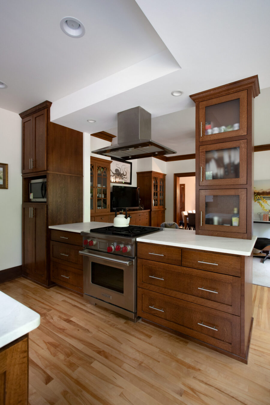 Elegant Twin Cities kitchen remodel features dark cabinetry, white counters, stainless steel appliances.