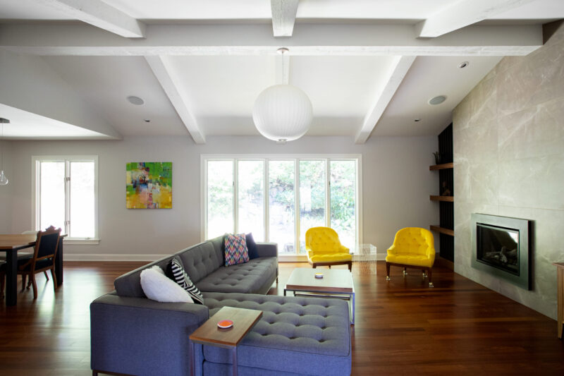 Modern Twin Cities remodel shows beamed ceilings, wood floors, and a tiled fireplace.