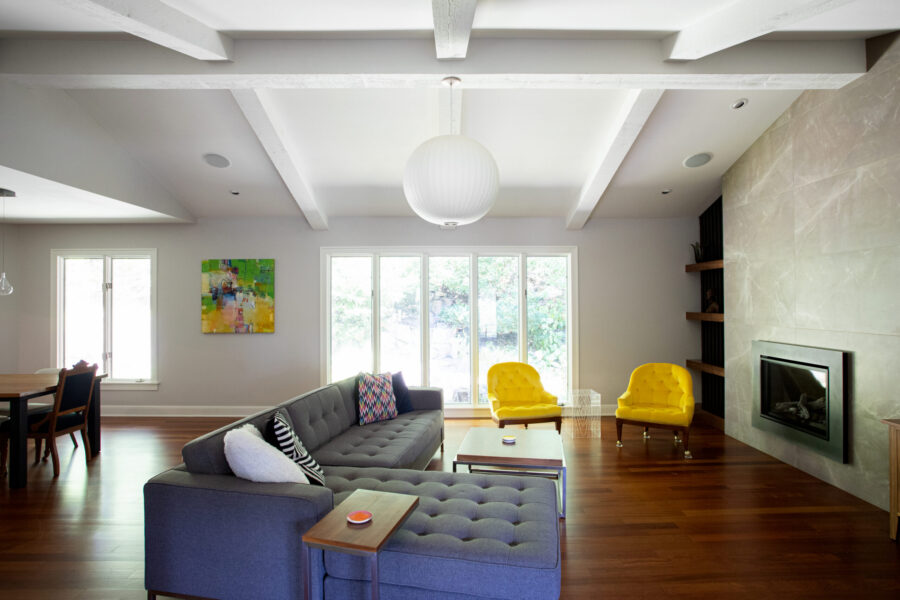Modern Twin Cities remodel shows beamed ceilings, wood floors, and a tiled fireplace.