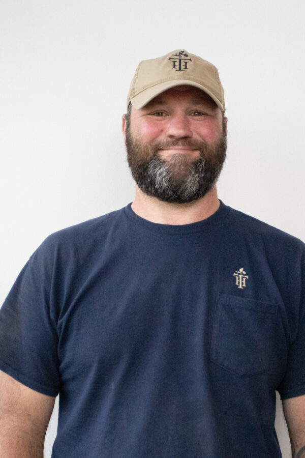 Bearded individual wears practical home renovation apparel; white background.
