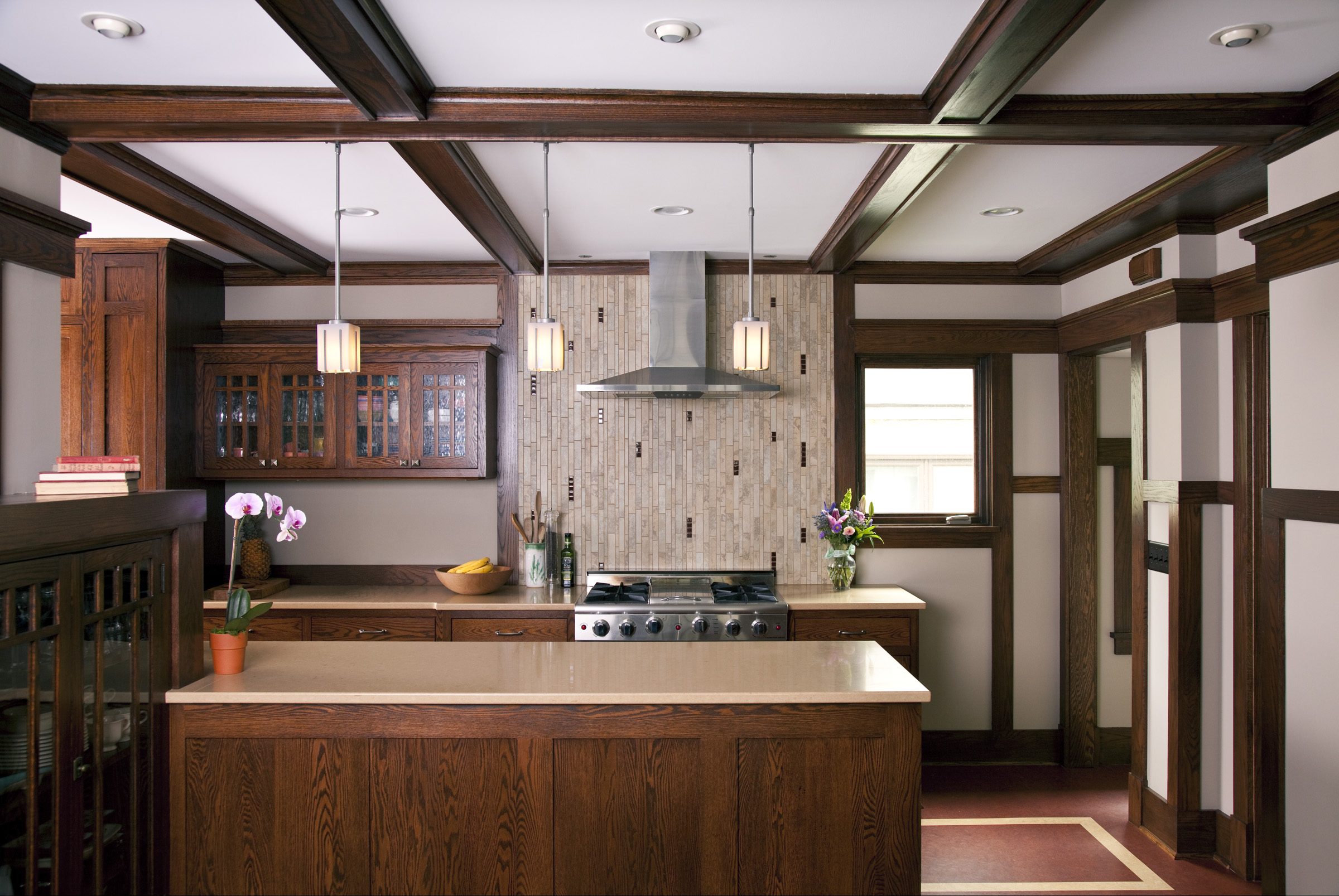Traditional kitchen with dark wood cabinets, beige island countertop, and a stainless steel range hood above a gas stove
