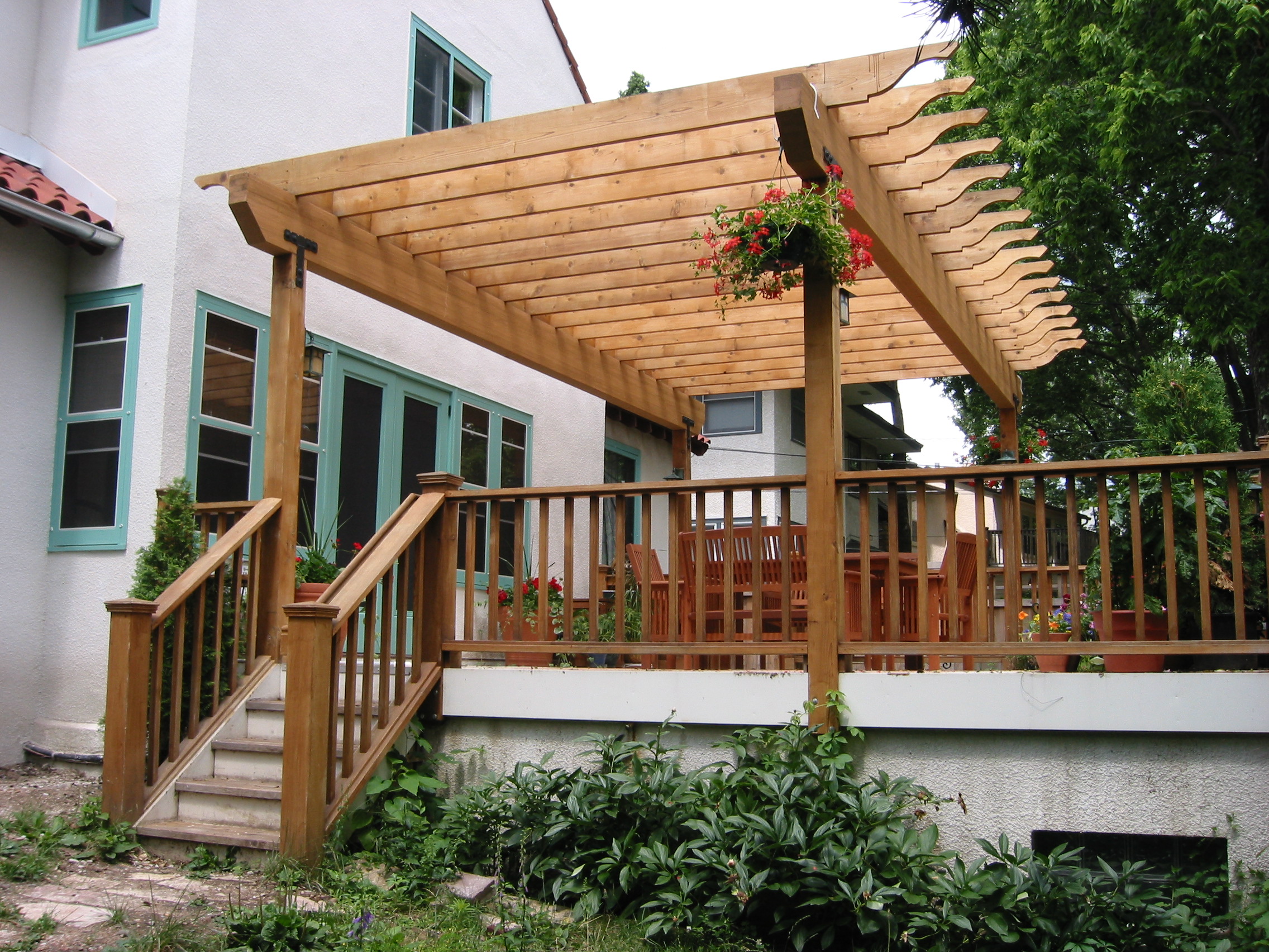 Wooden pergola and deck with railing overlooking a home addition in Minneapolis.