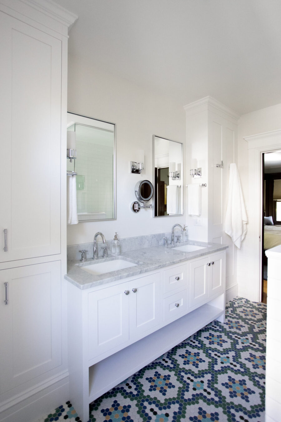 White double-sink bathroom vanity with marble countertop, mirrors, and white towels in a bright, modern space.